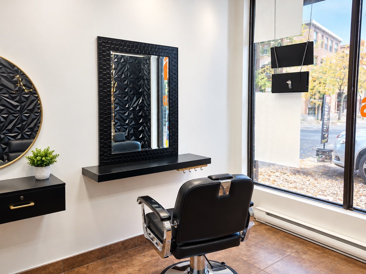 Le coin coiffure homme du salon : fauteuil de barbier et miroir
