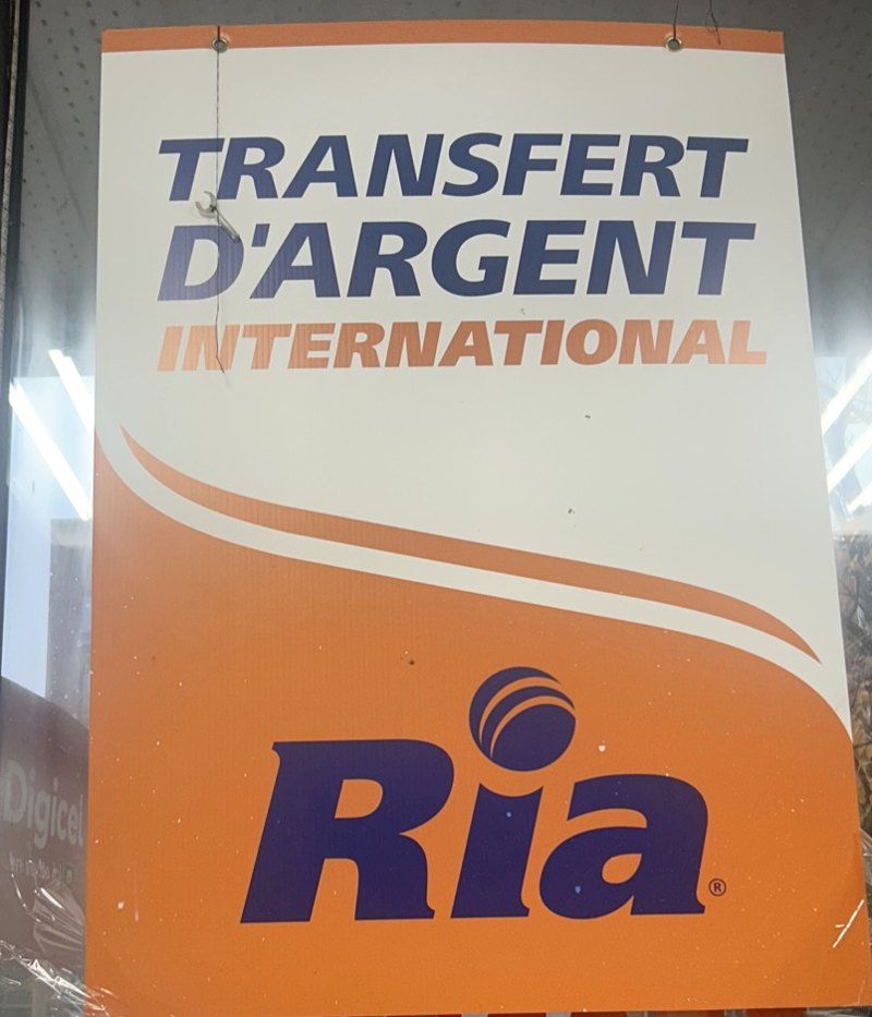 Affiche officielle Ria dans la vitrine du salon : Transfert d’argent international